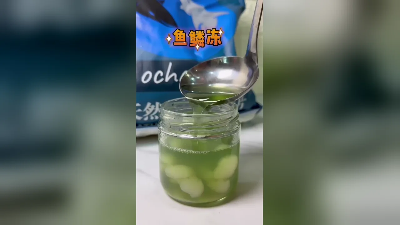 Jeli sisik ikan bunga telang dan longan dalam balang, dengan isi longan kelihatan di dasar
