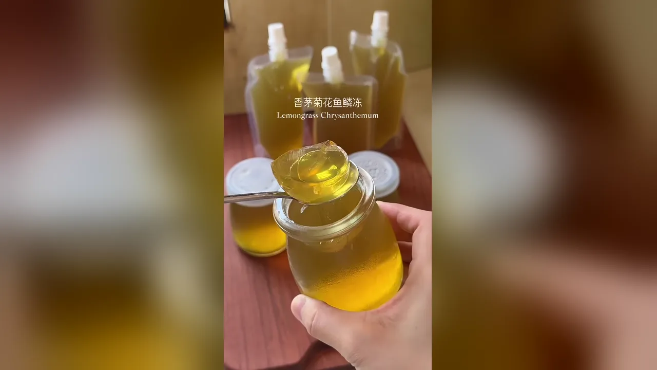 Sesendok jeli sisik ikan krisan dan serai keemasan diangkat dari toples, kantong minuman di belakang