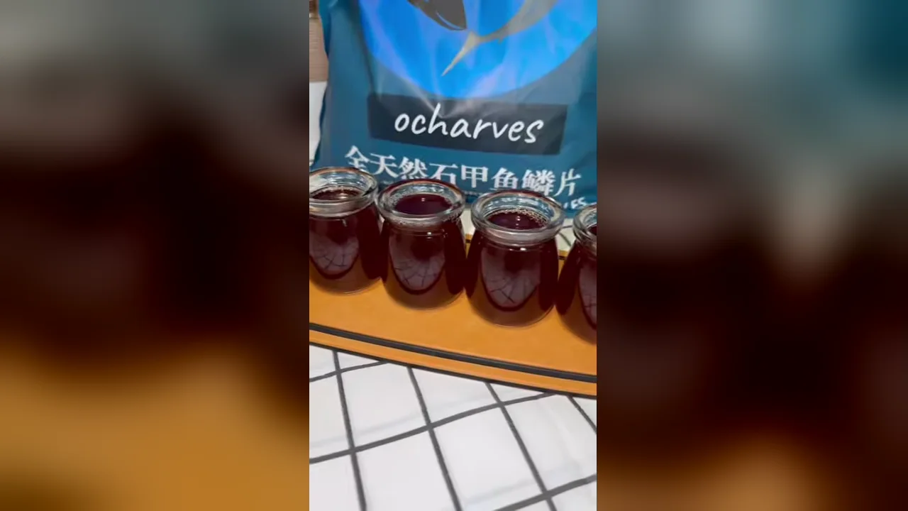 Empat botol jeli sisik ikan rosela siap, merah delima bening, di depan kemasan sisik ikan ocharves